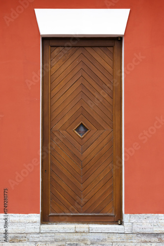 Wallpaper Mural A tall wooden door featuring a chevron pattern sits within a vivid red wall Torontodigital.ca