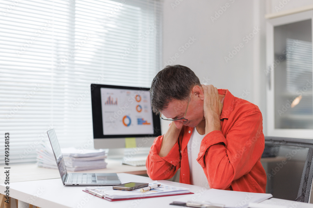 Fototapeta premium Man experiencing neck pain working in office