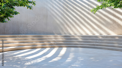 Minimalist amphitheater steps with shadows from trees create serene atmosphere