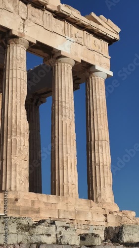 Side perspective of the Parthenon temple on the Acropolis in Athens, Greece, captured during golden hour. ancient marble columns and the harmony of classical architecture against the blue sky