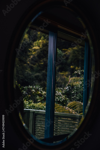 Fotografía de un espejo con el bosque de Coromandel en su reflejo en Nueva Zelanda.