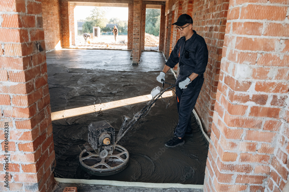 Fototapeta premium Holding the device for leveling the floor, concrete. Builder is working on construction site, unfinished building
