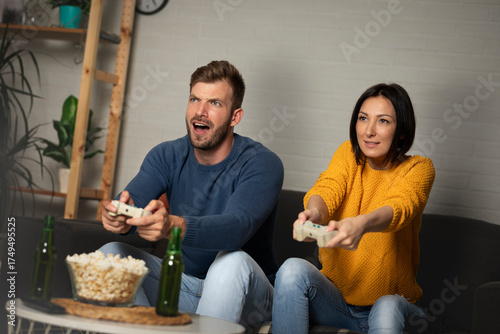 Young couple playing video games at home