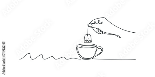 Hand dipping tea bag into cup