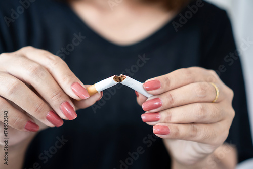woman’s hand breaking a cigarette in half, symbolizing quitting smoking, health awareness, and freedom from addiction. Perfect for no smoking, anti-tobacco, and healthy lifestyle