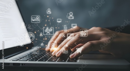 Close up of a person s hands typing on a laptop keyboard with glowing digital icons floating above the screen