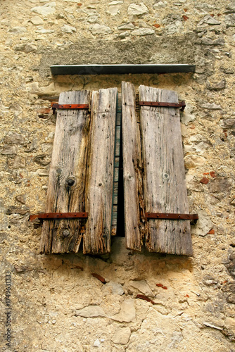 View of a wall with a window with old wooden shutters