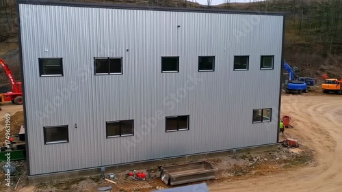 Construction of a new modern industrial warehouse building with metal siding.