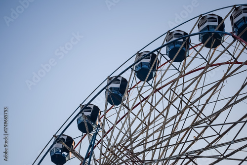 Closeup of multi-coloured Giant Wheel during Dussehra Mela in Delhi, India. Bottom view of Giant Wheel swing. Ferris wheel with colourful cabins during evening time.