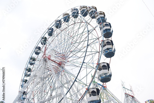 Closeup of multi-coloured Giant Wheel during Dussehra Mela in Delhi, India. Bottom view of Giant Wheel swing. Ferris wheel with colourful cabins during evening time.