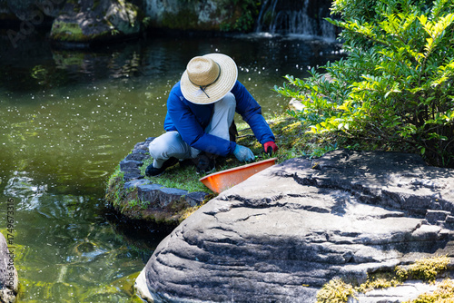giardiniere in un giardino giapponese taglia il prato
