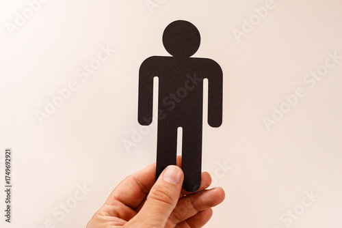 A hand holds a black silhou...