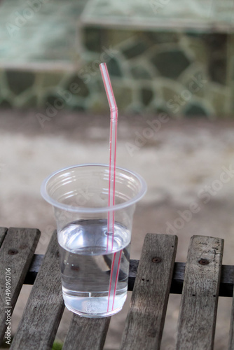 Plastic cup of water with pink straw