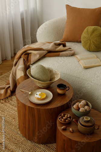 Close-up of cozy interior details – tea set, dessert and natural textures on a wooden table. Warm, inviting scene with autumnal tones.