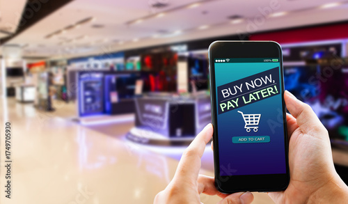 BNPL Buy now pay later online shopping concept.Hands holding mobile phone on blurred store as background