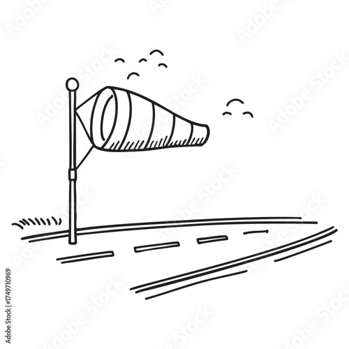 A windsock fluttering beside a runway with markings on the asphalt