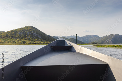 Wallpaper Mural A tranquil boat bow leads the way across a quiet lake, framed by rolling mountains Torontodigital.ca
