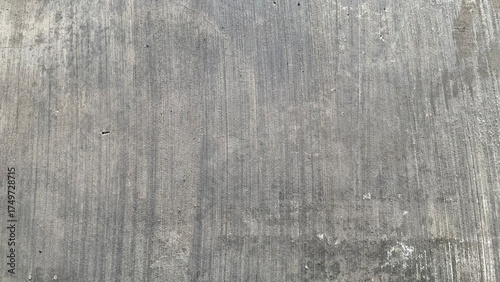Detailed full-frame background texture of a smooth, brushed cement wall with subtle vertical striations in various shades of light and dark industrial gray. Construction concept
