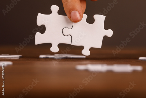 Tableau sur toile A hand placing a puzzle piece to connect with another