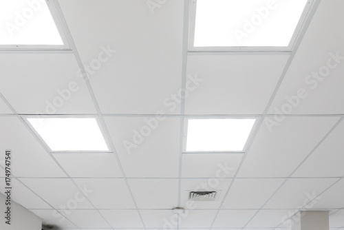 White ceiling with panel lighting. Light panels integrated in suspended ceiling, neutral colour temperature, optimal office lighting. Real photo