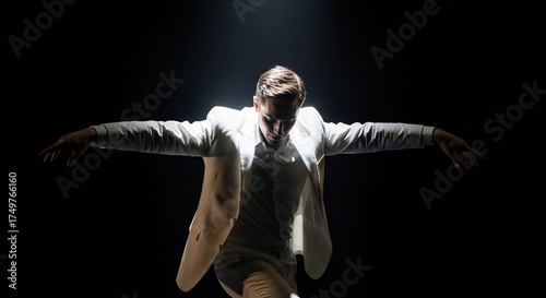 Dynamic dance performance with male dancer showcasing expressive movement in spotlight. Dance performance emphasizes grace and energy with captivating gestures and posture.