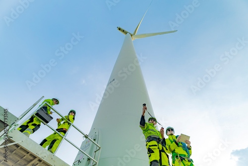 Foto A team of engineers inspects and maintains a large wind turbine at a renewable energy wind farm