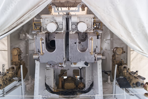 Military equipment view inside a covered gun installation at a naval base during daytime