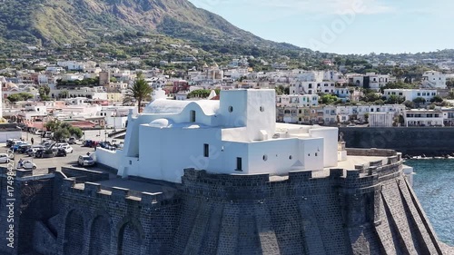Beautiful white church Santa Maria del Soccorso
in Forio of Ischia island in Italy coastal drone shot with deep blue sea waves, cliffs and sunny weather. 