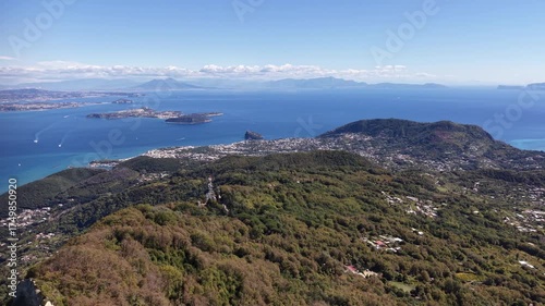 Beautiful coastal drone shot of Ischia island in Italy with deep blue sea waves, cliffs and sunny weather. 