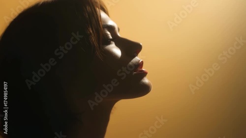 woman with flowing hair tears gently rolling down her cheeks stands against clean monochromatic background