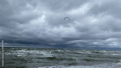 Kitesurfing on the waves on a cloudy gray day