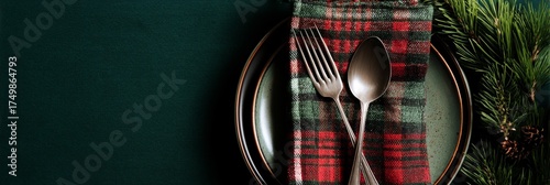 Dinner Setting With Plaid Napkin and Silverware on Dark Plate