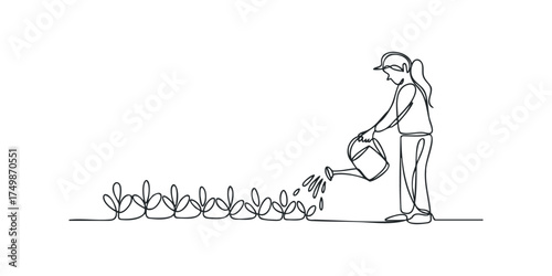 Person watering small plants with watering can