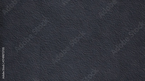 Dark textured surface with subtle grain and shadow for backgrounds.