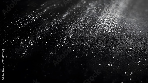Tiny shimmering particles are scattered across a dark surface.