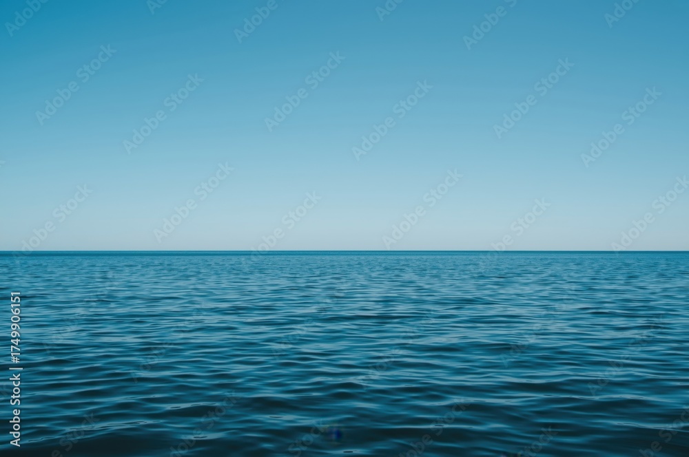 Fototapeta premium Calm blue sea meets the horizon under a vast clear sky capturing tranquil seascape beauty