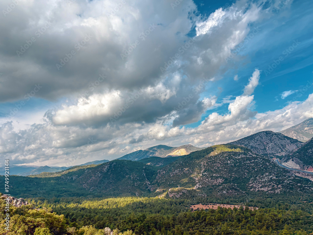 Fototapeta premium Wide valley view under cloudy sky with mountain ridges and forests