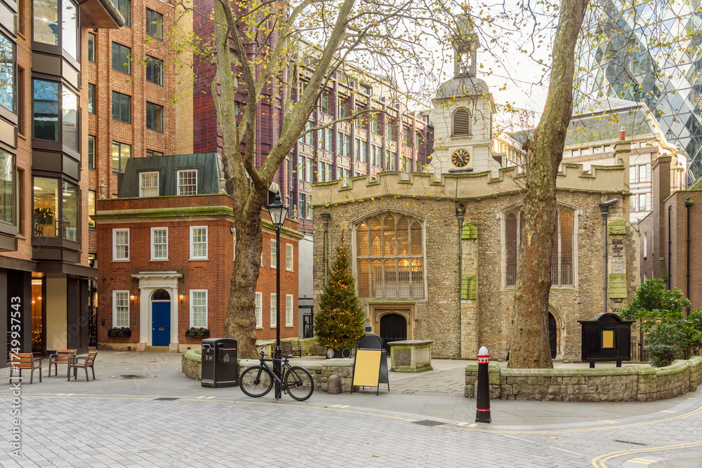 Fototapeta premium Small old stone church surrounded by office buildings in the City of London in winter