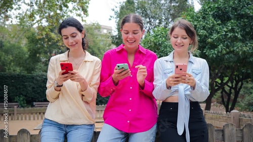 A delightful moment captured of three women engrossed in their smartphones as they interact on social media, showcasing modern connectivity and the joy of sharing experiences in a group setting.
