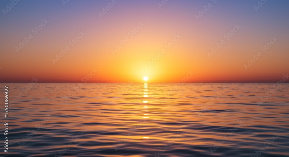 Fototapeta premium Ocean sunset horizon scene with vibrant orange and yellow colors reflecting on calm water