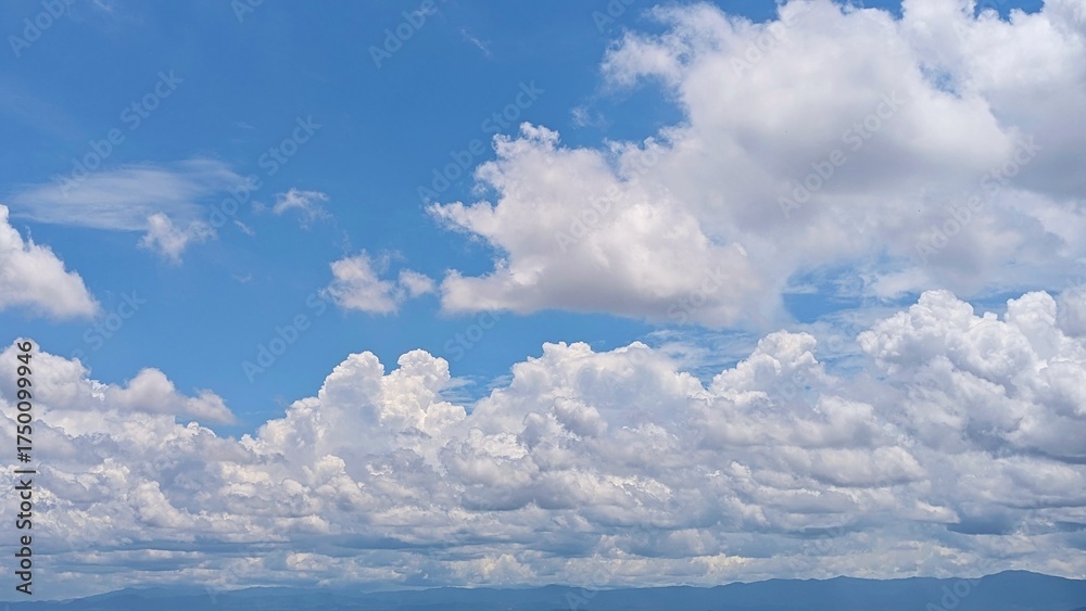 Fototapeta premium Natural landscape with fluffy white clouds under blue sky.