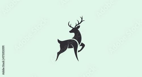 Graceful Black Deer Silhouette with Antlers on Light Green Background.