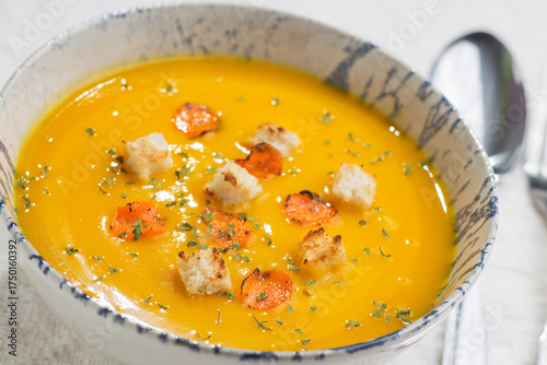 Pumpkin cream soup with toasted bread and carrot slices