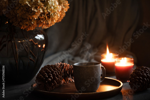 Cozy interior with coffee, aroma candles served in living room. Autumn moody. Scandinavian home decoration. Close up.