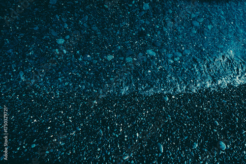 pebbly sea shore in dark blue color