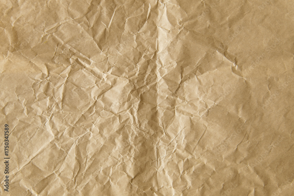 Fototapeta premium Crumpled brown paper texture with many wrinkles and folds.
