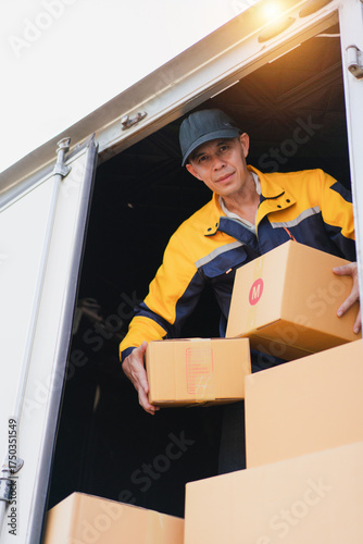 Worker Loading Delivery Boxes into Truck at Warehouse During Daylight for Logistics and Shipping Operations