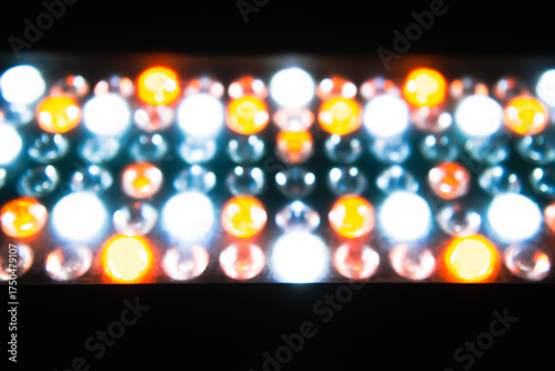 A close-up view of colorful LED lights glowing in a grid pattern, blending warm orange and cool white tones.