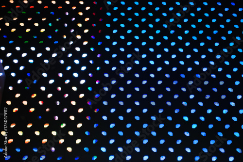 Close-up background of a vibrant LED light panel, displaying a grid of small, glowing dots in various colors.