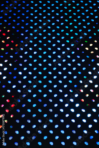 Close-up background of a vibrant LED light panel, displaying a grid of small, glowing dots in various colors.